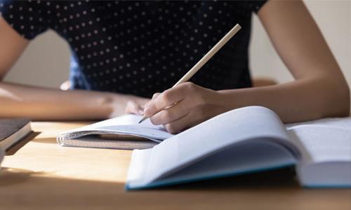 A student writing in a notebook